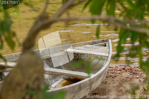 Image of Small rowing boat on the shore of a small river