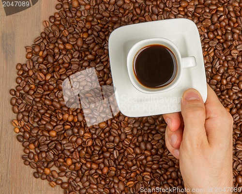Image of Cup of coffee on beans. top view