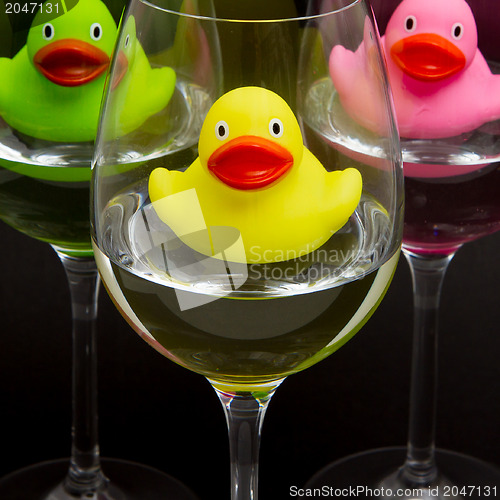 Image of Green, yellow and pink rubber ducks in wineglasses