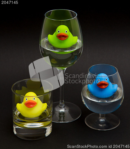 Image of Green, yellow and blue rubber duck in different glasses