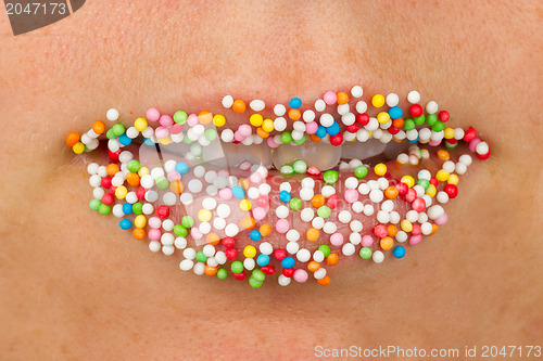 Image of Woman lips with multicolored pearls 
