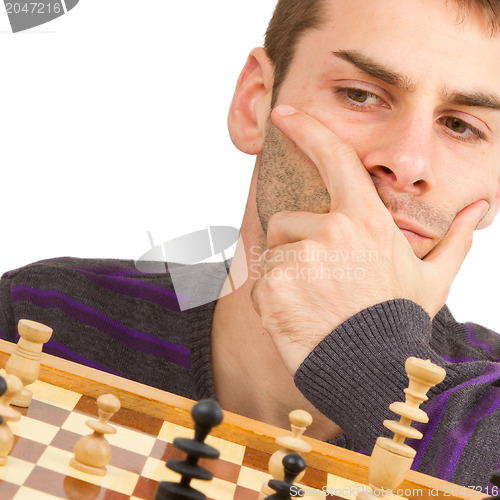 Image of Chessboard with desperate man thinking about chess strategy, iso