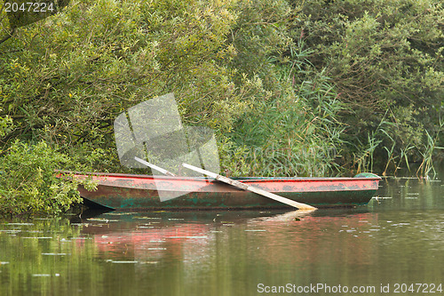 Image of Red rowing boat on lake