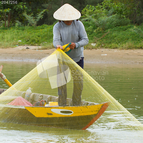 Image of Fisherman is fishing with a large net in a river in Vietnam