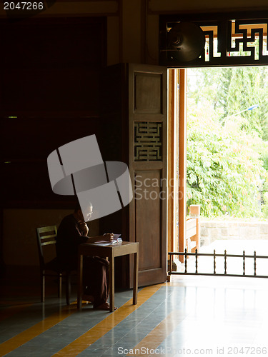 Image of DA NANG, VIETNAM - JULY 28: Buddhist monk writing in a book in t