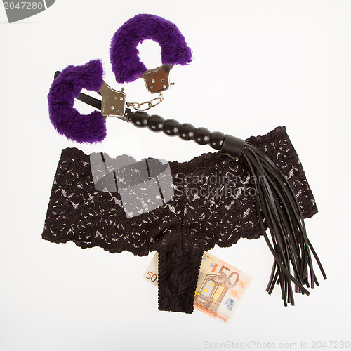 Image of Fluffy purple handcuffs, a whip, money and panties, prostitution