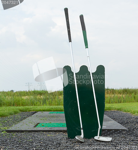 Image of Two golf clubs standing