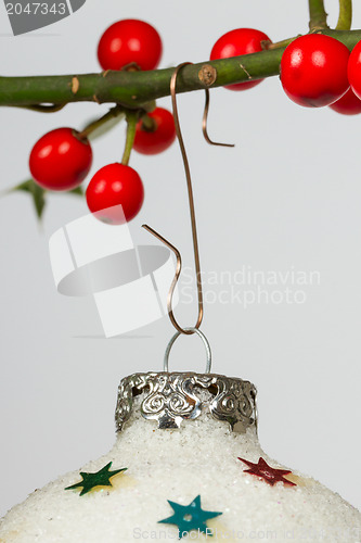 Image of Very old silver christmas ball hanging from a twig (butchers bro