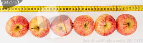 Image of Red apples with a yellow tape-measure