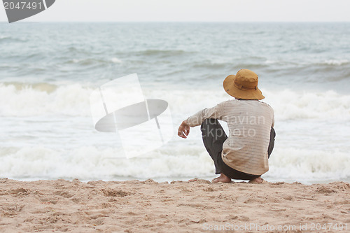 Image of Man sitting on the beach at the south chinese sea 