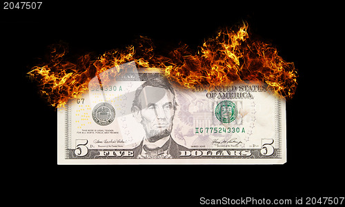 Image of Burning five dollar bill symbolizing careless money management