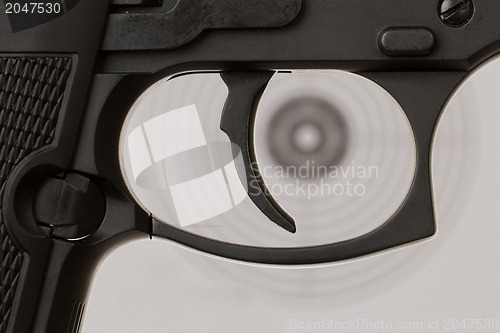 Image of The trigger of a handgun with a shooting target 
