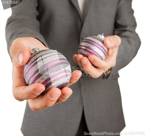 Image of Man in grey suit is holding Christmass balls