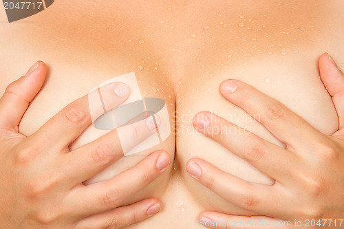 Image of Hands covering breasts