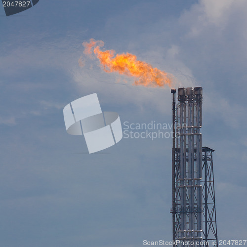 Image of Burning oil gas flare during sunset 