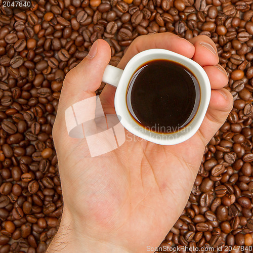 Image of Cup of coffee on beans. top view