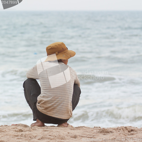 Image of Man sitting on the beach at the south chinese sea 