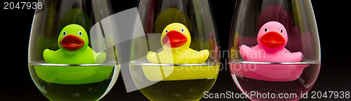 Image of Green, yellow and pink rubber ducks in wineglasses