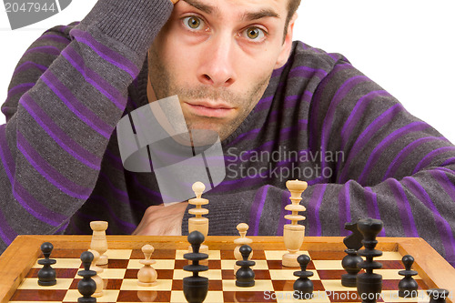 Image of Chessboard with desperate man thinking about chess strategy, iso