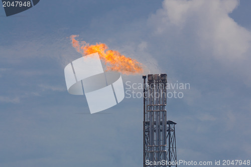 Image of Burning oil gas flare during sunset 