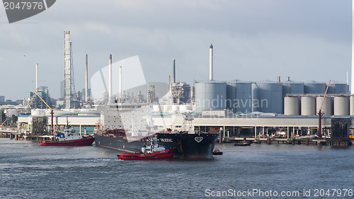 Image of Two tugboats manoeuvring an oil tanker in the dutch harbor of Ro