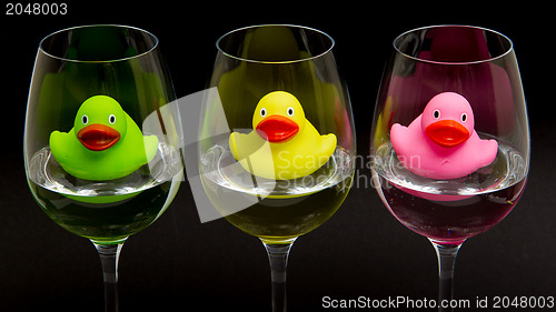 Image of Green, yellow and pink rubber ducks in wineglasses