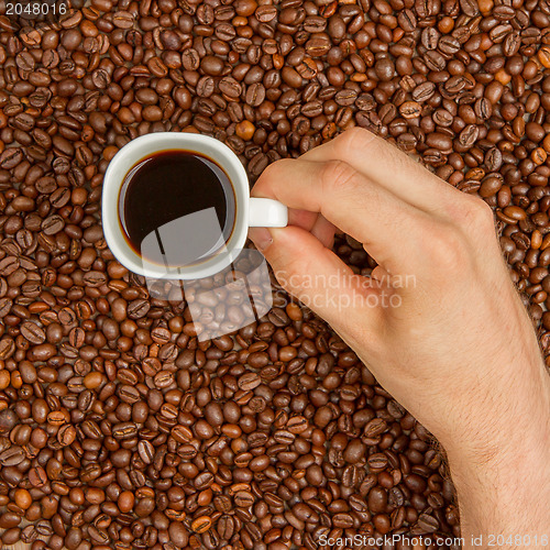 Image of Cup of coffee on beans. top view