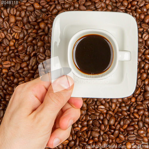 Image of Cup of coffee on beans. top view