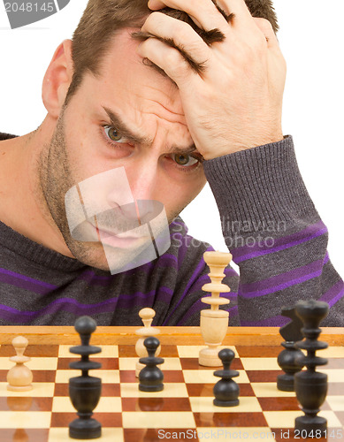 Image of Chessboard with desperate man thinking about chess strategy, iso