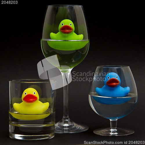 Image of Green, yellow and blue rubber duck in different glasses