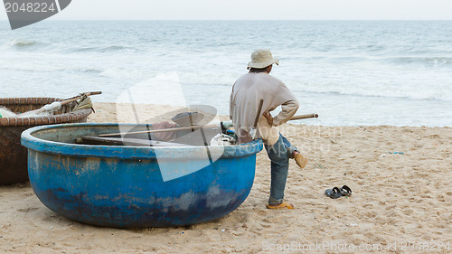 Image of Unidentified man with Vietnamese fishing boat