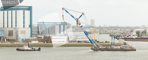 Image of Tug-boat dragging a crane