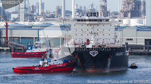 Image of Two tugboats manoeuvring an oil tanker in the dutch harbor of Ro