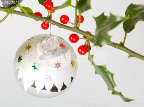 Image of Very old silver christmas ball hanging from a twig (butchers bro