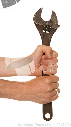 Image of Old rusted adjustable vector wrench in a hand