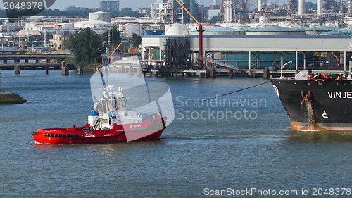 Image of Two tugboats manoeuvring an oil tanker in the dutch harbor of Ro