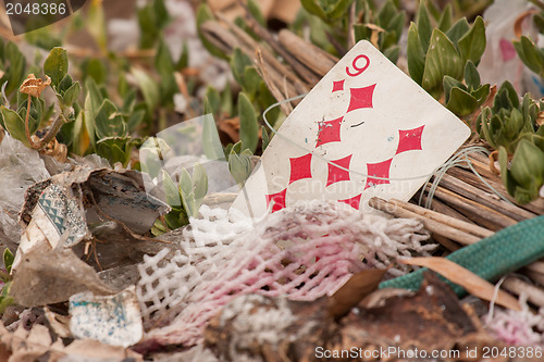 Image of Old playing card on a pile of garbage