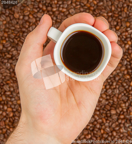 Image of Cup of coffee on beans. top view