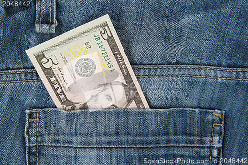 Image of Macro shot of trendy jeans with american 5 dollar bill