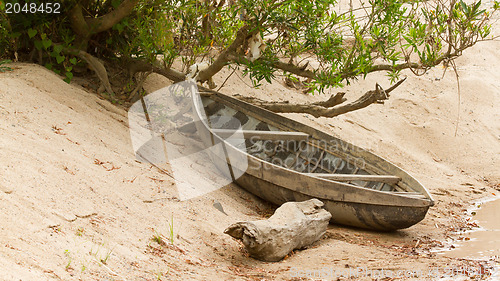 Image of Small rowing boat on the shore of a small river