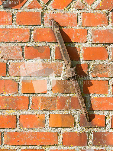 Image of Old rusty clamp in a brick wall