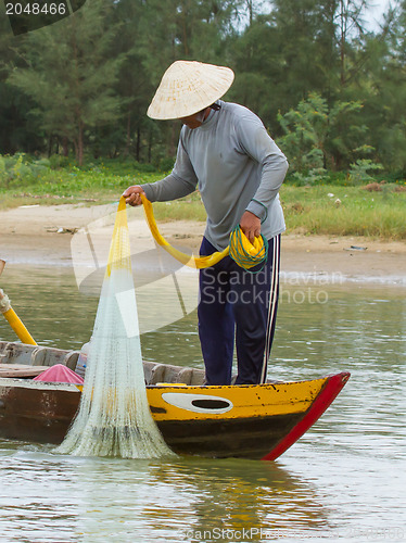 Image of Fisherman is fishing with a large net in a river in Vietnam