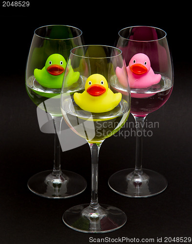 Image of Green, yellow and pink rubber ducks in wineglasses