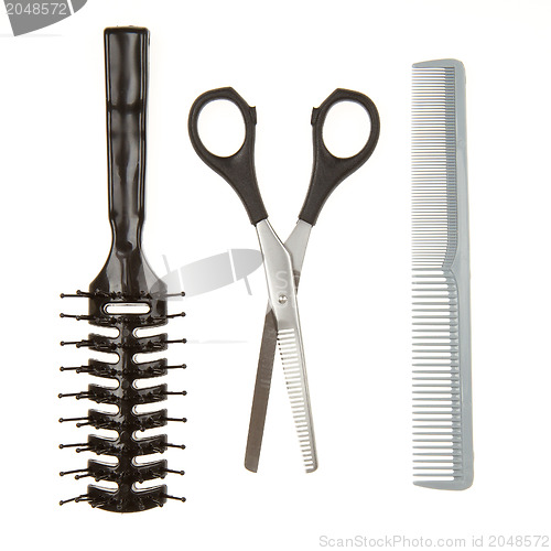 Image of Cutting scissors or shears and black comb and a black brush