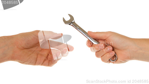 Image of Woman giving wrench to man