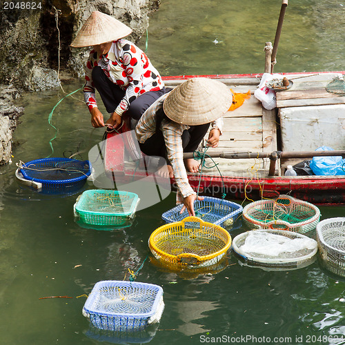 Image of HA LONG BAY, VIETNAM AUG 10, 2012 - Food seller in boat. Many Vi