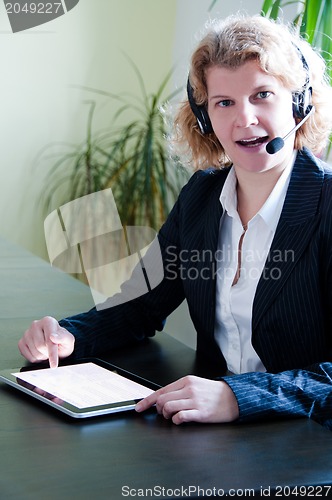 Image of Business woman with digital tablet PC and headset