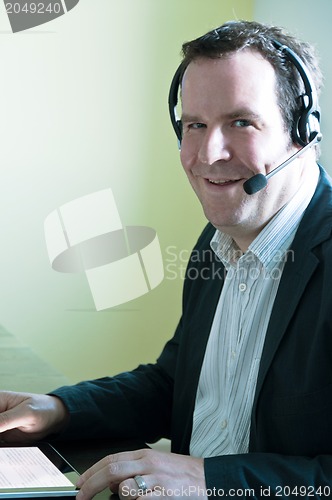 Image of Businessman with digital tablet PC and headset