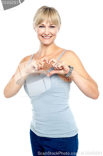 Image of Romantic middle aged woman gesturing heart shape