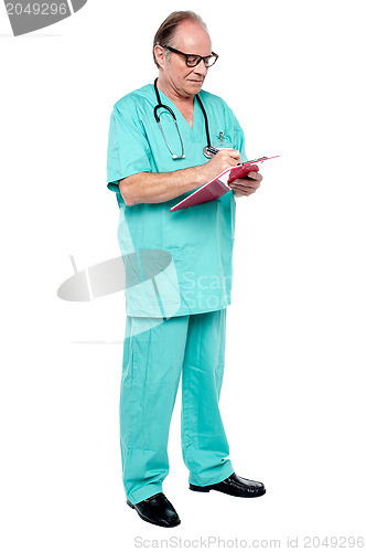 Image of Mature medical practitioner writing case history of a patient